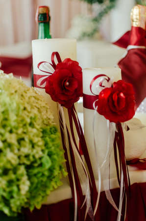 White wedding candles decorated with red roses and ribbons. Wedding decorationsの写真素材