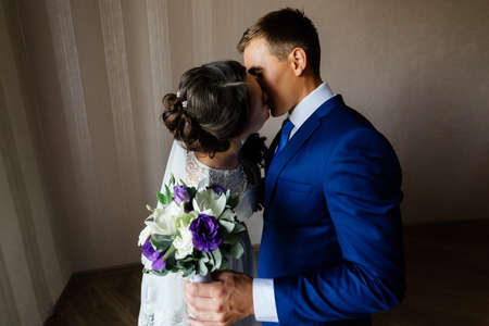 The bride and groom embrace and kiss. Bride and groom kissing. Wedding couple in love at wedding dayの写真素材