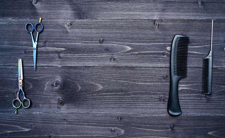 Hairdresser tools on wooden background. Top view on wooden table with scissors and combl, free space. Barbershop, manhood conceptの写真素材