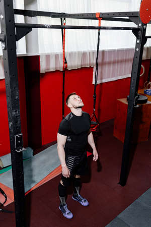 Muscular bearded man preparing to training his biceps and back in gym. Pull-ups. Workout lifestyle...