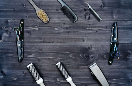 Hairdresser tools on wooden background. Top view on wooden table with scissors, comb, hairbrushes and hairclips, free space. Barbershop, manhood conceptの写真素材
