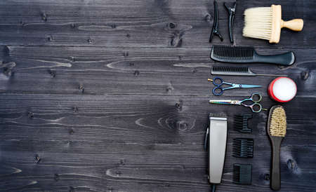 Hairdresser tools on wooden background. Top view on wooden table with scissors, comb, hairbrushes...