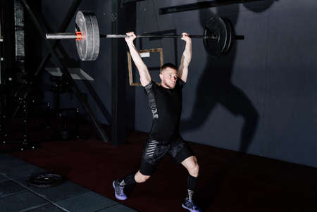 Fit young  athlete lifting the barbell in gym. Gym trainingの写真素材