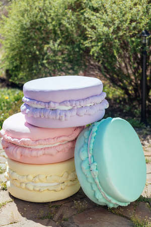 Big colorful artificial french macaroon. Wedding decoration in French style outdoorsの写真素材