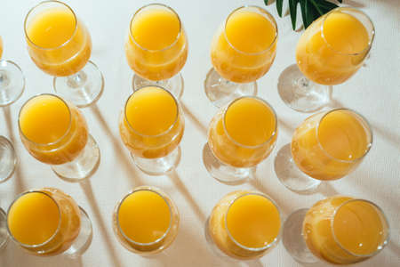 Glasses with tasty fresh orange fruit juice on summer wedding greeting. Top viewの写真素材