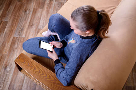White smartphone screen in the girl's hands.Technology and communication conceptの写真素材