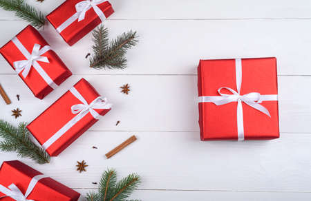 Christmas background with red gift boxes, fir tree branches, pine cones, cinnamon sticks and stars...