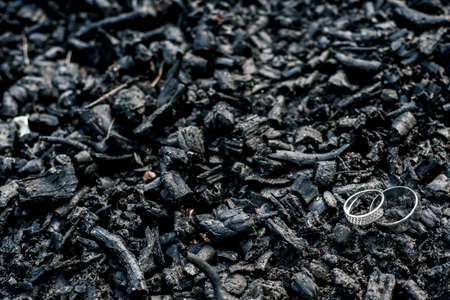 Golden wedding rings on black charcoa, selective focus, tilt-shift, free space