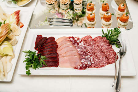 Sausage plate variation on white plate. Plate with different kinds of sausages on dinner tableの写真素材
