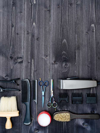 Hairdresser tools on wooden background. Top view on wooden table with scissors, comb, hairbrushes and hairclips, free spaceの写真素材