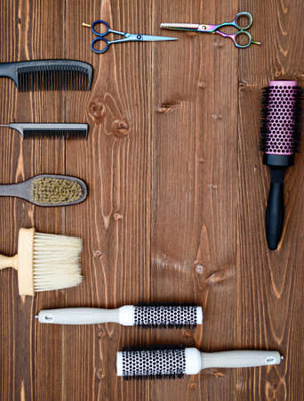 Hairdresser tools on wooden background. Top view on wooden table with scissors, hairbrushe and comb, free space. Barbershop, manhood conceptの写真素材
