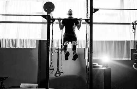 Muscular bearded man training his biceps and back in gym. Pull-ups. Workout lifestyle conceptの写真素材