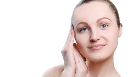 Portrait of a girl with nude make-up with hands near her face isolated on white background. Girl with clean healthy skin on white. Cosmetology, spa, medicine, beauty care. Beauty model. Nude makeupの写真素材