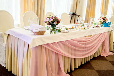 Beautiful wedding bouquet of roses in glass vase on the dinner table. Floral Wedding Decorationsの写真素材