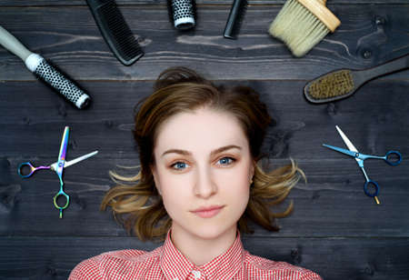 Happy young woman in plaid shirt with hairdresser tools among her. Top viewの写真素材