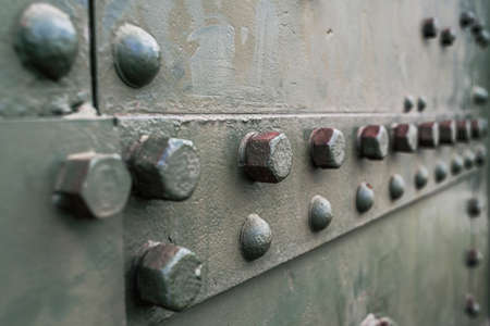 Abstract green industrial metal background texture with bolts and rivets. Old painted metal background, detail of military aircraft, surface corrosion, metal texture with rivetsの写真素材
