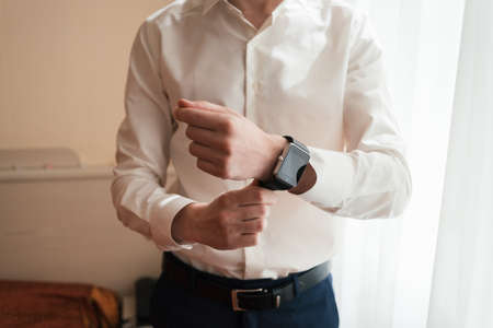 Watch on the wrist of man in white shirtの写真素材