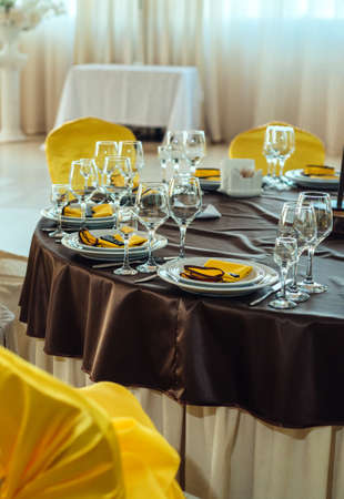 Serving table in restaurant with wine glasses and cutlery. Table served for wedding banquet. Table...