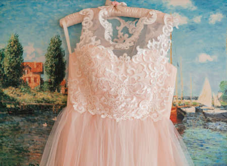 Lace top wedding dress hanging on the wallの写真素材