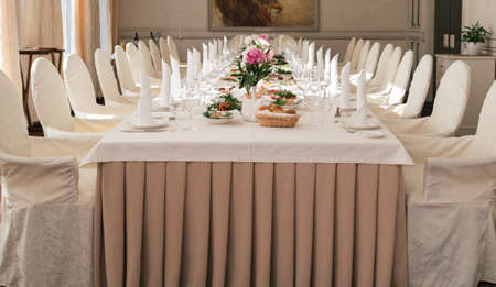Chairs with white cloth and table for guests served for wedding banquet with flowers. Peony on dinner table for wedding banquetの写真素材