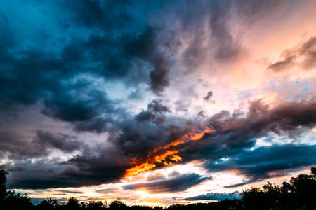 Dramatic gray, blue and orange sunset on beautiful sky, free space. Sky background on sunset with...