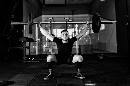 Fit young  athlete lifting the barbell in gym. Gym training の写真素材
