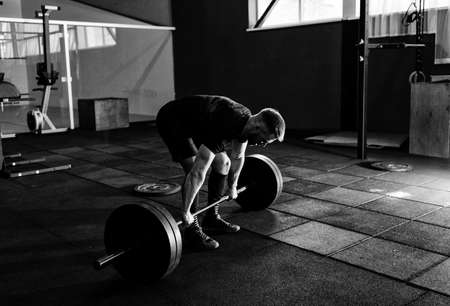 Fit young  athlete lifting the barbell in gym. Gym training の写真素材