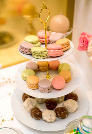 French colorful macaroons on cake stand. Birthday party. Holiday candy bar, free space. Table with sweets. Catering in the restaurantの写真素材