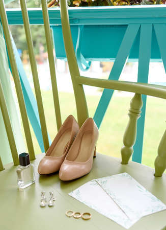 Wedding accessories, selective focus. Bridal shoes, earrings, perfume bottle, wedding rings and luxury invitations with blank copy space. Wedding morning conceptの写真素材