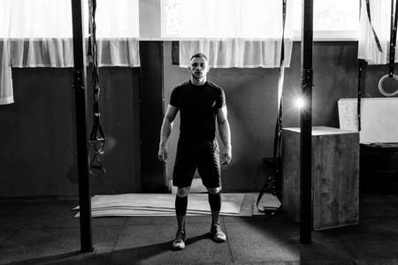 Muscular bearded man preparing to training his biceps and back in gym. Pull-ups. Workout lifestyle concept. Full body length portraitの写真素材