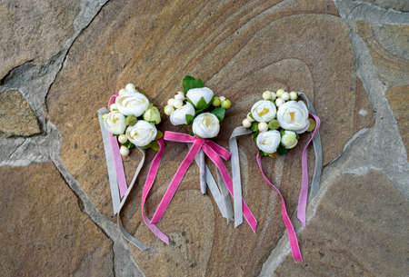 Top view of wedding boutonniere for the groom and bridesmaids on stone background, free space. Wedding details outdoor with copy space. Wedding morning preparationの写真素材