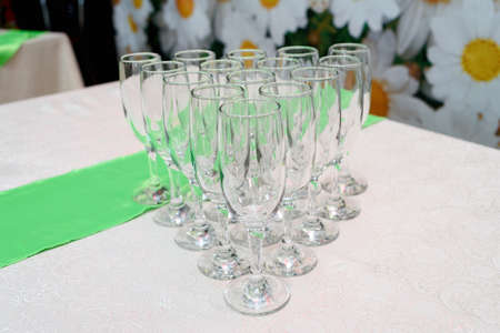 Rows of empty glasses for champagne on the table, selective focus, free space. Set of sparkling glassware in restaurant, close upの写真素材