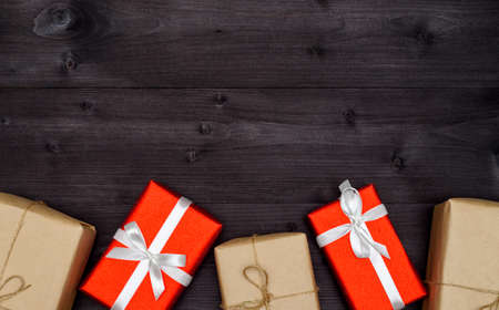 Red and kraft gift boxes border on wooden background, copy space. Holiday greeting card. Mothers day, birthday, Women's Day, mum's day, Valentine's day, Christmas, Wedding. Top view, flat layの写真素材