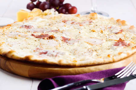 Fresh cheese pizza with ham and cream sauce on white plate, close up. Italian traditional cuisine, copy space. Food, shallow depth of fieldの写真素材