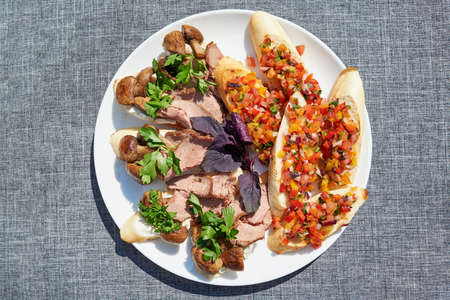 Mini sandwiches with cream cheese, mushrooms and beef. Appetizer bruschetta with chopped vegetables on  taosted baguette. Antipasti, crostini, tapas on party or picnic time. Flat lay, top viewの写真素材