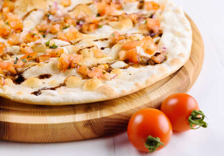 Fresh traditional italian focaccia bread with tomatoes, onions, rosemary and olive oil on wooden board, selective focus. Healthy homemade flatbread focaccia, copy spaceの写真素材