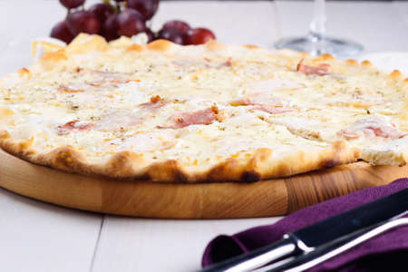 Fresh cheese pizza with ham and cream sauce on white plate, close up. Italian traditional cuisine, copy space. Food, shallow depth of fieldの写真素材