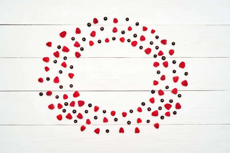 Circle frame from ripe sweet raspberries and black currants, free space. Fresh berries on white...