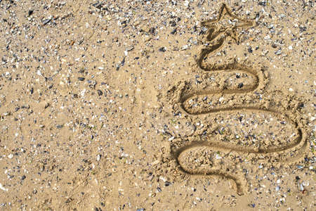 Christmas tree drawn on sand background, copy space. Holiday concept. Happy New Year, top viewの写真素材