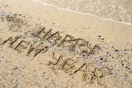 Happy new year written on tropical beach sand, copy space. Holiday conceptの写真素材