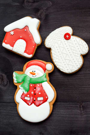 Christmas background with tasty homemade gingerbread cookies with icing on wooden table, top view, flat lay. Snowman, snowflake, house. Christmas food, copy spaceの写真素材