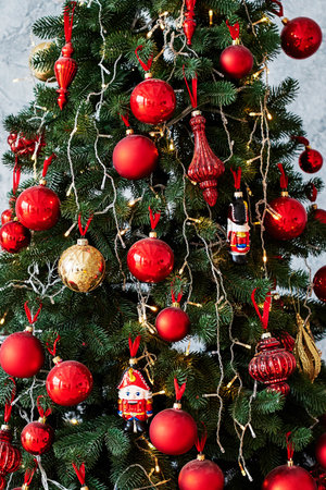 Christmas tree decorated with red and gold baulbes, garland light, copy space. Winter holidays or New year concept, close upの写真素材