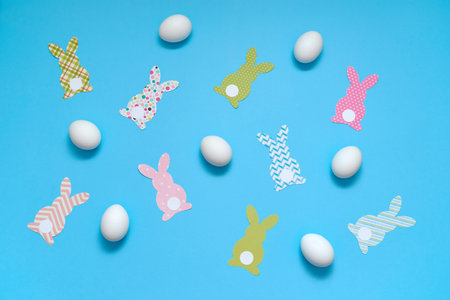 Easter bunny decoration and eggs on blue background, copy space. DIY holiday handicraft. Flat lay, top view. Happy Easter conceptの写真素材
