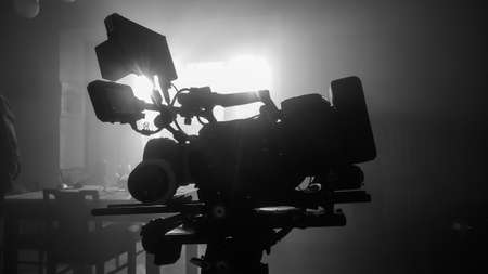 movie camera on the slider in the backlight from the window, the rays of the sun in a smoky room