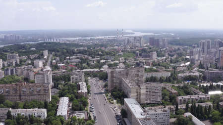 smooth drone take-off up over the summer streets of the green city (Kiev) against the background of the big river (Dnipro) Ukraineの写真素材