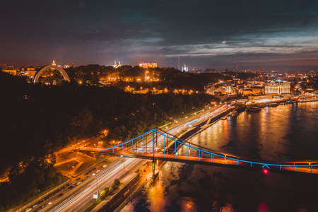 night cityscape. aerial view. colorful led bridge across river and quay road in Kyivの写真素材