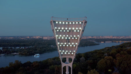 Switching on the light tower of a football stadium against a sunset and a night city cinematic smooth movement of a droneの写真素材
