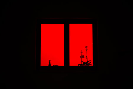 red light from the window. the red window shines mystically at night. mysterious red windowの写真素材