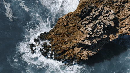 ocean waves hit the rock, topshot aerial view in Portugalの写真素材