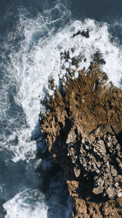 ocean waves hit the rock, topshot aerial view in Portugal, vertical, 9:16の写真素材